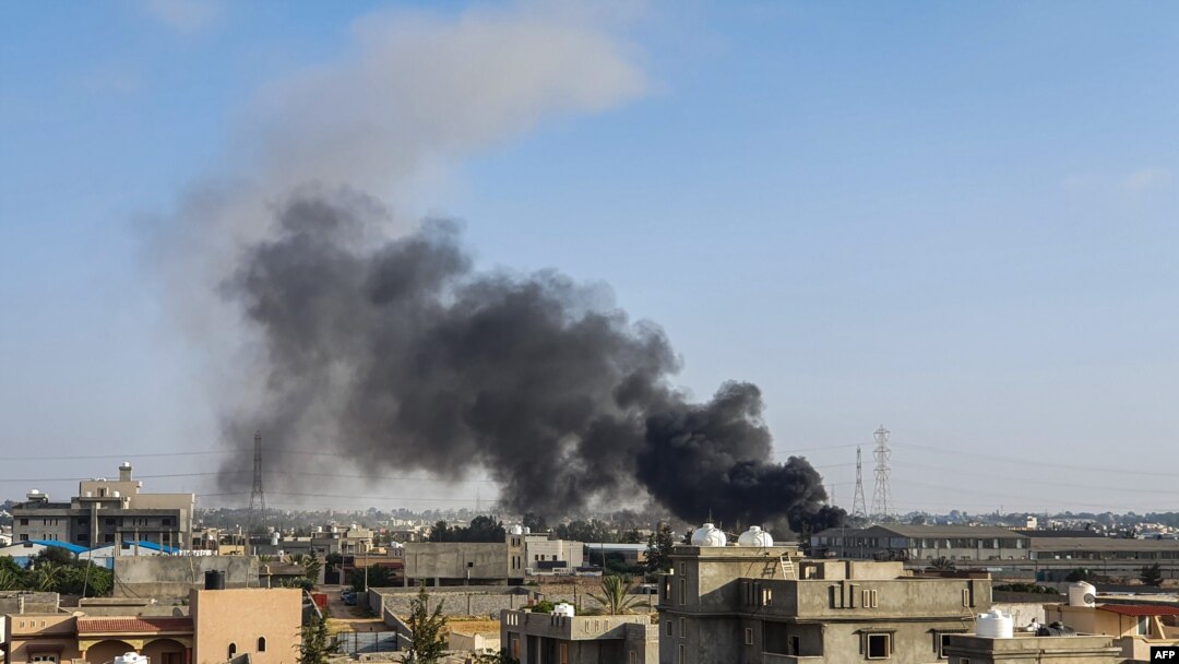 FILE - A smoke plume rises in Tajoura, south of the Libyan capital Tripoli, June 29, 2019, following a reported airstrike.