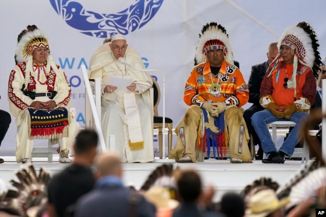 Surrounded by Grand Chiefs, Pope Francis reads his statement of apology during a visit with Indigenous peoples at Maskwaci, the former Ermineskin Residential School, Monday, July 25, 2022, in Maskwacis, Alberta. Pope Francis traveled to Canada to apologize to Indigenous peoples for the abuses committed by Catholic missionaries in the country's notorious residential schools. (AP Photo/Eric Gay)