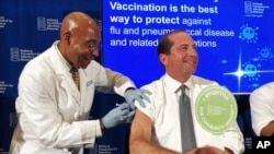 B.K. Morris gives Secretary of Health and Human Services Alex Azar a flu shot to during a news conference in Washington, Sept. 26, 2019. Health officials urged Americans not to delay getting their flu shot.