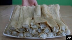 An employee displays a popular North Korean street food snack called Injogogibap in Korean at a restaurant in Incheon, South Korea, April 15, 2016. 