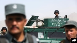 Afghan security forces inspect site of suicide attack after clashes with Taliban fighters at the gate of an intelligence facility in Kabul, July 7, 2015.