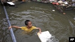 A Thai boy in a flooded area in Bangkok, Thailand. Hundreds of people died across Southeast Asia, China, Japan and South Asia in the last four months from prolonged monsoon flooding, typhoons and storms in October 2011.