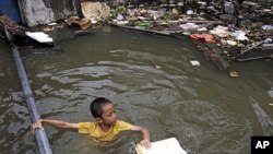 A Thai boy plays at a flooded area in Bangkok, Thailand. Hundreds of people have died across Southeast Asia, China, Japan and South Asia in the last four months from prolonged monsoon flooding, typhoons and storms, October 3, 2011.