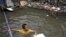 A Thai boy plays at a flooded area in Bangkok, Thailand. Hundreds of people have died across Southeast Asia, China, Japan and South Asia in the last four months from prolonged monsoon flooding, typhoons and storms, October 3, 2011.
