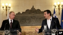 Greek Prime Minister Alexis Tsipras , right, and Russian President Vladimir Putin address to journalists during a joint press conference after their meeting in Athens, Friday, May 27, 2016. 