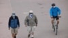 Personas usan tapabocas en un paseo frente a la playa en Huntington Beach, California, el 1 de julio de 2020.