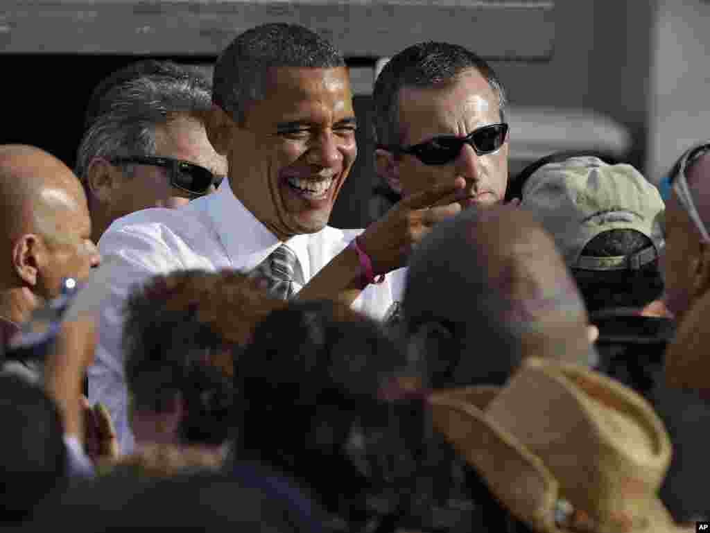 Le pr&eacute;sident Barack Obama riant avec un partisan apr&egrave;s un meeting &agrave; Tampa, en Floride 