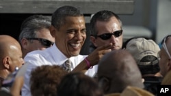 奥巴马总统在佛罗里达坦帕的一次竞选造势集会发表讲话后和支持者一道欢笑（2012年10月25日）。