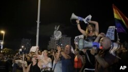 Israelis take part in a weekly protest against Israeli Prime Minister Benjamin Netanyahu, seen on the poster, in front of the home of Israel's attorney general, Avichai Mandelblit, in Petah Tikva, Aug. 26, 2017. 