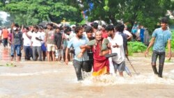 People wade through a flooded street in Nellore, in the southern Indian state of Andhra Pradesh, Nov. 20, 2021.