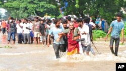 Warga melewati jalanan yang tergenang banjir di Nellore, di negara bagian Andhra Pradesh, India selatan, 20 November 2021.