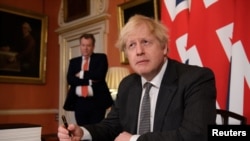 Le Premier ministre britannique Boris Johnson pose pour une photo après avoir signé l'accord commercial sur le Brexit aà Londres, Grande-Bretagne, le 30 décembre 2020. Leon Neal / Pool via REUTERS