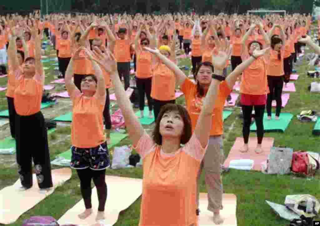 Taiwanese perform yoga poses at the start of International Yoga Day in Taipei, Taiwan, June 21, 2015. Equipped with yoga mats and humming the sounds of Om, over two thousand people in Taipei city performed the 108 rounds of the Sun Salutation Sunday marki