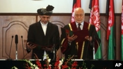 El presidente Ashraf Ghani Ahmadzai (izquierda) es juramentado por el juez Abdul Salam Azimi. Ghani ha firmado el esperado acuerdo de seguridad con EE.UU.