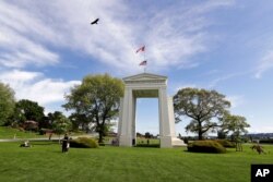 A bird flies from the U.S. into Canada over the Peace Arch in Peace Arch Historical State Park on the border with Canada, where people can walk freely between the two countries at an otherwise closed border in Blaine, Washington, May 17, 2020.