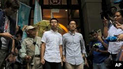 FILE - Pro-democracy activists Joshua Wong, center left, and Nathan Law, center right, walk out of the Court of Final Appeal Hong Kong, Oct. 24, 2017. 