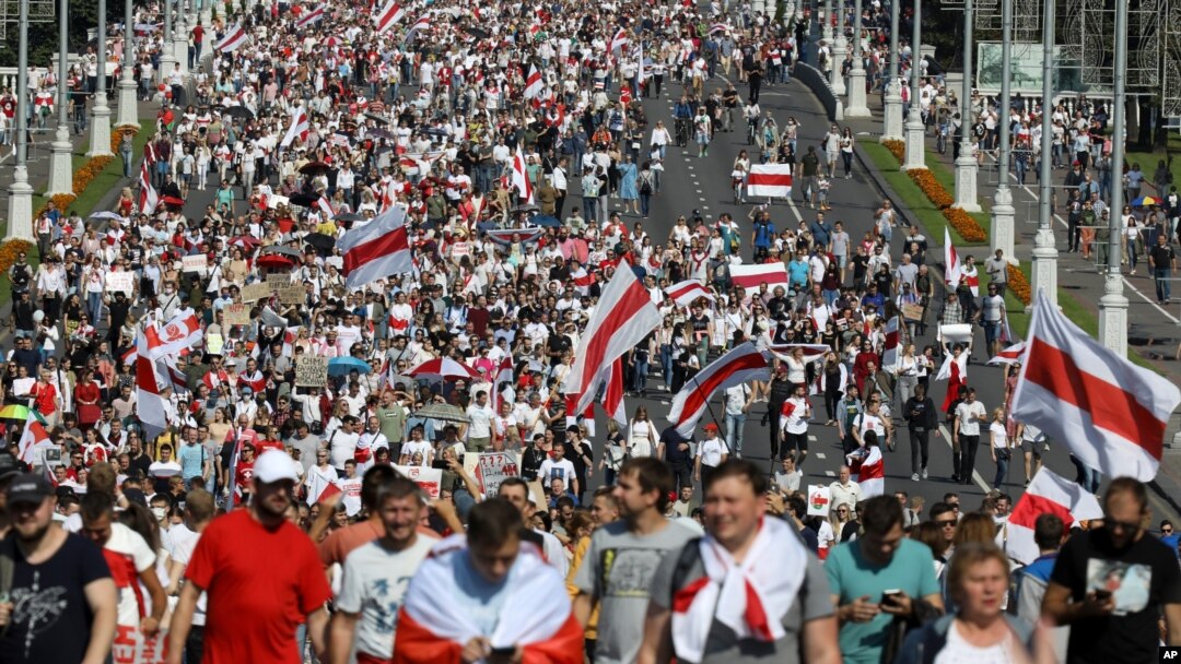 Belarusian opposition supporters with old Belarusian national flags rally in Minsk, Belarus, Aug. 30, 2020. 