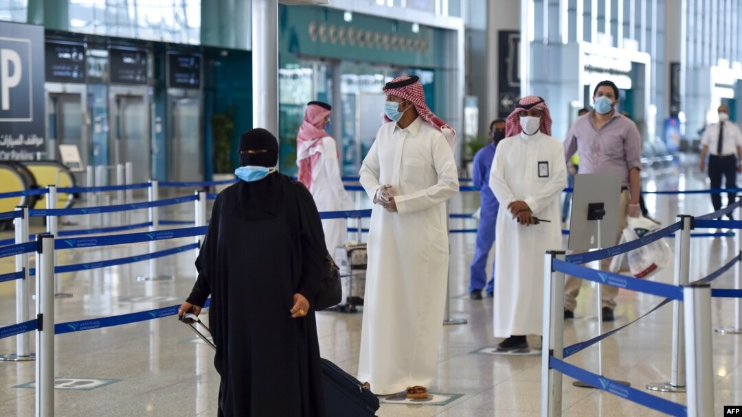 Penumpang Saudi mengantri untuk pemeriksaan suhu di terminal 5 di Bandara Internasional Raja Fahad, yang ditujukan untuk penerbangan domestik, di ibu kota Riyadh pada 31 Mei 2020. (Foto: AFP)