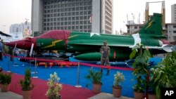 FILE - A Pakistan army soldier stands guard near a combat aircraft, jointly developed by China and Pakistan, displayed at the International Defense Exhibition and Seminar (IDEAS) 2014, in Karachi, Pakistan, Dec. 2, 2014. 