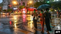 ရန်ကုန်မြို့ထဲ တနေရာတွင် လမ်းဖြတ်ကူးနေသူတချို့။ (ဇွန် ၁၄၊ ၂၀၂၀)