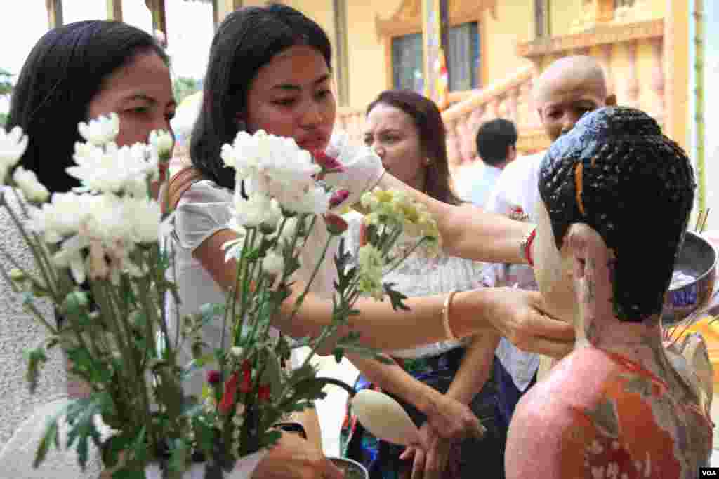 ប្រជាពលរដ្ឋខ្មែរ ស្រង់ព្រះនៅថ្ងៃបុណ្យចូលឆ្នាំខ្មែរ ក្នុងវត្តមួយជាយរាជធានីភ្នំពេញ កាលពីថ្ងៃទី១៤ ខែមេសា ឆ្នាំ២០១៧។ (ហ៊ាន សុជាតា/VOA)