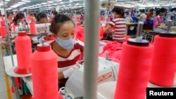 Labourers work at an assembly of Singapore's invested Singlun Star garment factory outside Hanoi August 19, 2014.