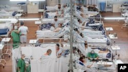 COVID-19 patients lie on beds at a field hospital built inside a sports coliseum in Santo Andre, on the outskirts of Sao Paulo, Brazil, Thursday, March 4, 2021. (AP Photo/Andre Penner)