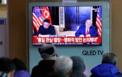 FILE - A TV shows a photo of U.S. President Donald Trump and North Korean leader Kim Jong Un, left, while people listen to Kim's New Year's speech, at Seoul Railway Station in Seoul, South Korea, Jan. 1, 2019.