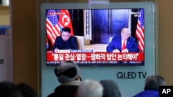 Sebuah acara TV memperlihatkan foto Presiden AS, Donald Trump, dan pemimpin Korut, Kim Jong Un, kiri, dan di saat yang sama tampak pemirsa menyimak pidato Tahun Baru Kim, di Stasiun Kereta Api Seoul, Korea Selatan, 1 Januari 2019 (foto: AP Photo/Ahn Young-joon)