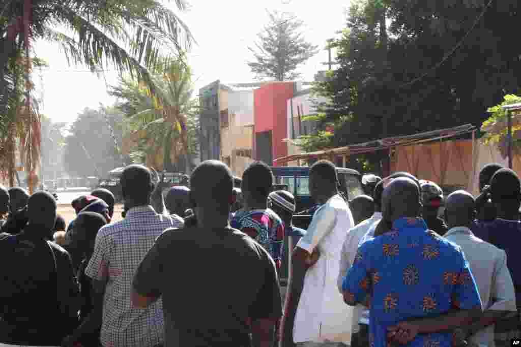 Pessoas assistem ao que se passa nos arredores do hotel Radisson Blu em Bamako