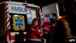 An injured woman is carried into an ambulance near the site where a Russian drone struck a high-rise residential building in Kyiv, Ukraine's western Solomianskyi district,. Oct. 25, 2024.