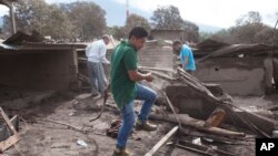 Óscar Chávez (centro), su hermano William (derecha), y su padre Francisco, buscan a su hermano Edgar Otoniel y su familia, su esposa Sandra y su hijo Josué, quienes están desaparecidos desde la erupción del Volcán de Fuego, en San Miguel Los Lotes, Guatemala. Junio 7 de 2018. 