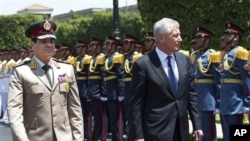 Menhan AS Chuck Hagel (kanan) berjalan berdampingan dengan Menhan Mesir Abdel-Fattah el-Sissi, dalam upacara menyambut kedatangan tamu negara di Kementrian Pertahanan Mesir di Kairo (24/3).