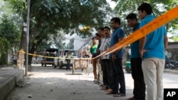 Bangladeshi police and detectives stand by the site where Italian citizen Cesare Tavella was gunned down by unidentified assailants in Dhaka, Sept. 29, 2015.