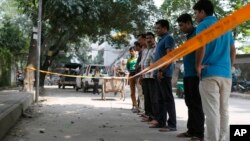 Bangladeshi police and detectives stand by the site where Italian citizen Cesare Tavella was gunned down by unidentified assailants in Dhaka, Sept. 29, 2015.