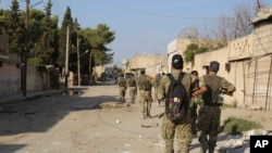 Turkey-backed Syrian fighters enter Ras al-Yan, Syria, Oct. 12, 2019. Turkey's military says it has captured the town of Suluk in the fifth day of its offensive in northeast Syria. The Kurds say the fighting is ongoing.