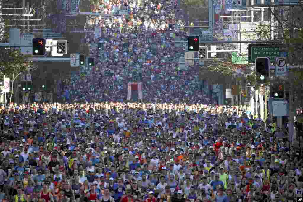 Peserta lomba lari berlari di sepanjang William Street saat lari gembira City2Surf dimulai di Sydney, Australia. Lomba lari tahunan sepanjang 14 km tersebut menarik ribuan pelari dari berbagai penjuru negara tersebut dan luar negeri.