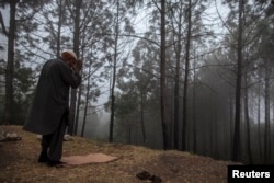 A man prays in the mist on Margalla Hills in Islamabad Nov. 6, 2013.