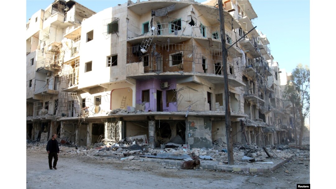 FILE - A man walks past damaged buildings in the rebel held besieged al-Sukkari neighbourhood of Aleppo, Syria, Oct. 19, 2016.