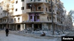 A man walks past damaged buildings in the rebel held besieged al-Sukkari neighbourhood of Aleppo, Syria, Oct. 19, 2016.