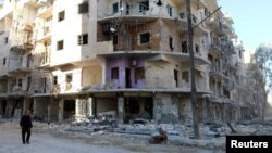 A man walks past damaged buildings in the rebel held besieged al-Sukkari neighbourhood of Aleppo, Syria, Oct. 19, 2016.