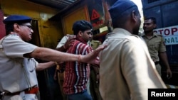 Police escort one of the four men convicted of raping a photojournalist outside a jail in Mumbai, March 21, 2014. 