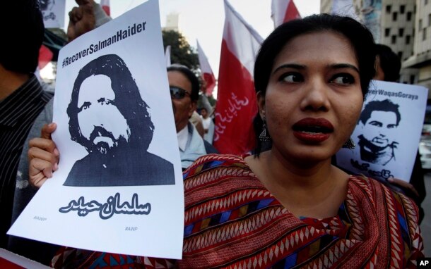 A woman holds a portrait of missing university professor and poet Salman Haider during a rally in support of Haider and other activists, in Karachi, Pakistan, Jan. 10, 2017.