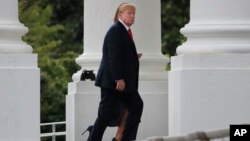 President Donald Trump and first lady Melania Trump walk on the North Portico as they arrive back to the White House in Washington, July 22, 2018, from weekend trip to Bedminster, N.J. 