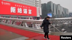 Seorang pria berjalan di jembatan dekat sebuah pusat perbelanjaan di tengah merebaknya wabah virus corona di Beijing, China, 6 Februari 2020.