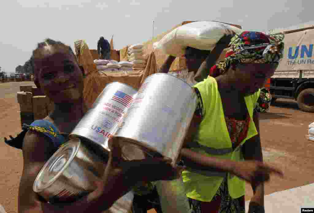 People collect food distributed by aid agencies at a camp for people displaced by the recent unrest, at the Mpoko international airport of Bangui, Feb. 12, 2014. 