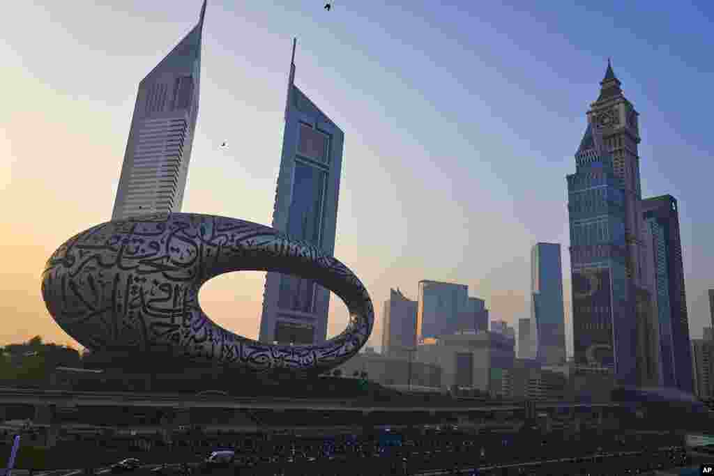 Bicyclists ride on a major highway with the Museum of the Future and Emirates Towers behind them in Dubai, United Arab Emirates. The annual Dubai Ride saw authorities shut down the skyscraper-lined super highway that cuts through the center of the city-state to allow bicyclists to ride on it.