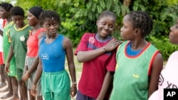 Young women coached by Isabelle Sambou, two-time Olympian and nine-time African wrestling champion, wait before a wrestling training session in Mlomp, southern Senegal, July 10, 2024.