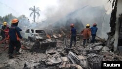 2015年6月30日救火人员在对坠毁的运输机引起的大火进行扑救。