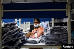 FILE - An employee sorts pieces of cloth at the Estee garment factory in Tirupur, in the southern Indian state of Tamil Nadu.